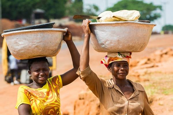 Women carrying large bowls on their heads in Ghana