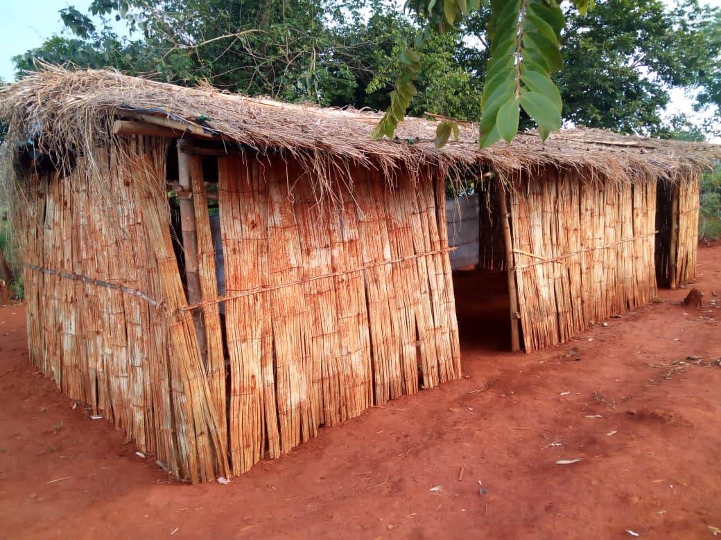 A building in Cameroon with red dirt floor and thatched roof